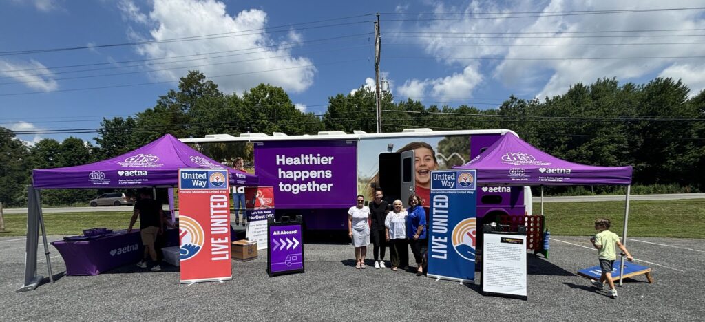 image of Aetna rv with United Way staff and screeners in front with purple tents and United Way signage.